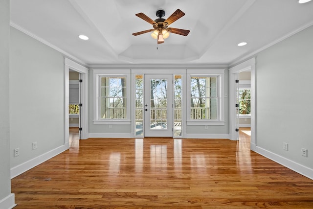 interior space featuring crown molding, light hardwood / wood-style flooring, a raised ceiling, and ceiling fan