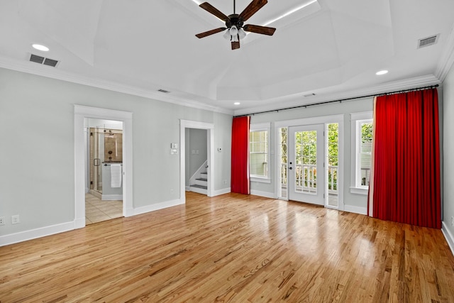 interior space with a raised ceiling, crown molding, ceiling fan, and light wood-type flooring