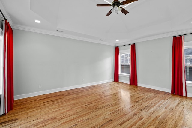 unfurnished room with crown molding, light hardwood / wood-style flooring, ceiling fan, and a tray ceiling