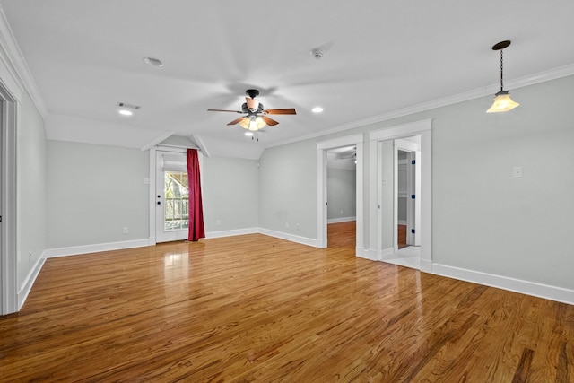 empty room with hardwood / wood-style flooring, vaulted ceiling, ornamental molding, and ceiling fan