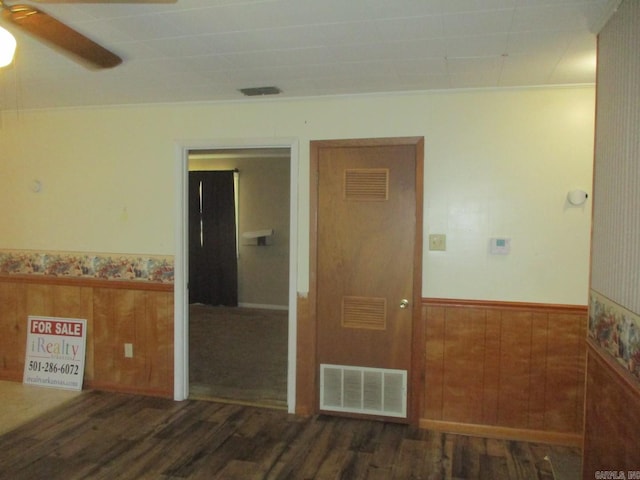 spare room featuring visible vents, wainscoting, a ceiling fan, and wood finished floors