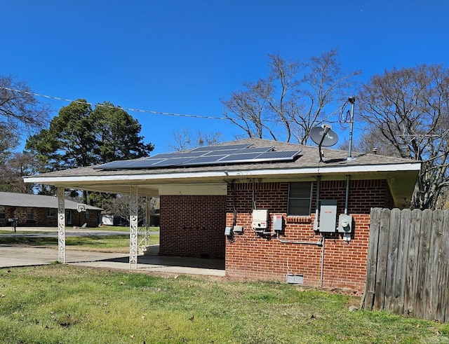 view of front of property featuring a front yard, a patio area, and solar panels