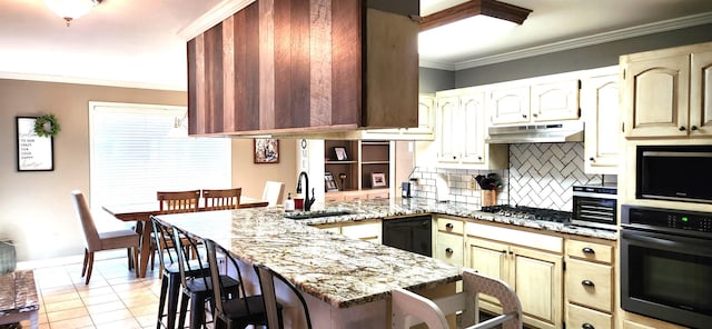 kitchen featuring sink, light stone counters, a kitchen breakfast bar, dishwasher, and oven