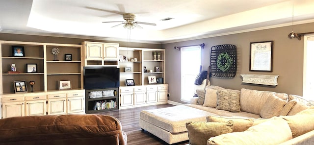 living room featuring ceiling fan, ornamental molding, dark hardwood / wood-style flooring, and a tray ceiling