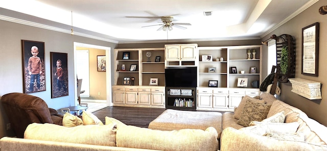 living room with ceiling fan, ornamental molding, dark hardwood / wood-style floors, and a raised ceiling