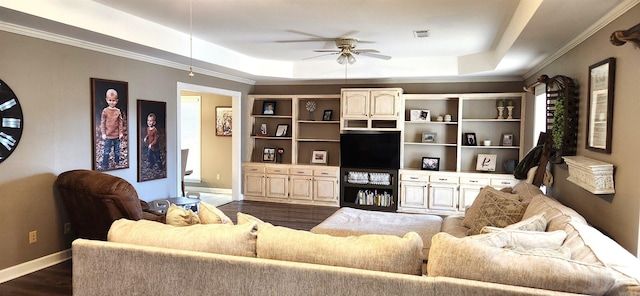 living room with dark hardwood / wood-style floors, ceiling fan, and a tray ceiling