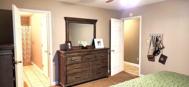 bedroom featuring light tile patterned floors, ensuite bath, and ceiling fan