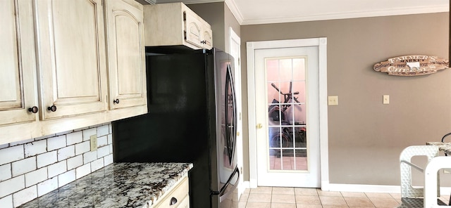 kitchen featuring light tile patterned flooring, tasteful backsplash, dark stone countertops, stainless steel fridge, and crown molding