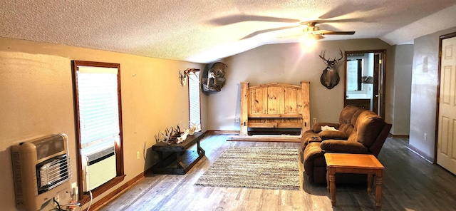 sitting room with lofted ceiling, heating unit, a textured ceiling, hardwood / wood-style flooring, and ceiling fan