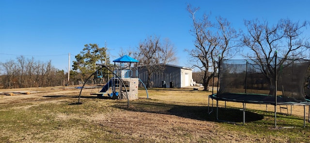 view of play area featuring a trampoline and a lawn