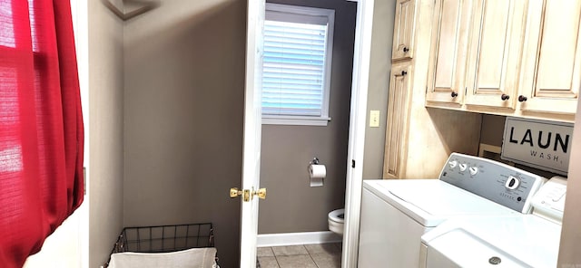 clothes washing area with light tile patterned floors, washing machine and dryer, and a wealth of natural light