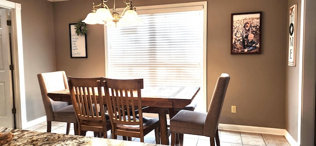 tiled dining room with a notable chandelier