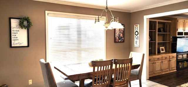 tiled dining area featuring ornamental molding and a chandelier