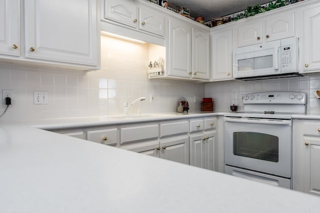 kitchen featuring backsplash, white appliances, sink, and white cabinets