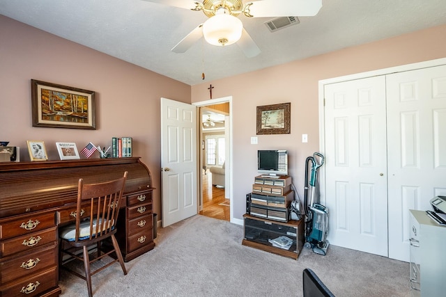 carpeted office space featuring ceiling fan