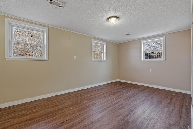 empty room featuring plenty of natural light, a textured ceiling, and dark hardwood / wood-style flooring