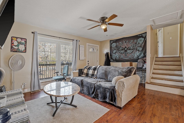 living room with ceiling fan, dark wood-type flooring, and a textured ceiling