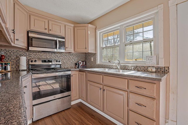 kitchen featuring sink, dark wood-type flooring, appliances with stainless steel finishes, tasteful backsplash, and a textured ceiling