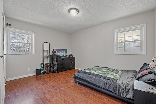 bedroom with wood-type flooring and a textured ceiling