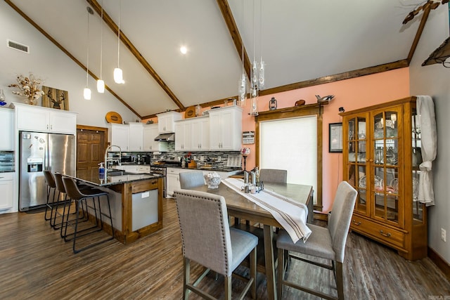 dining area featuring beamed ceiling, dark hardwood / wood-style flooring, and high vaulted ceiling