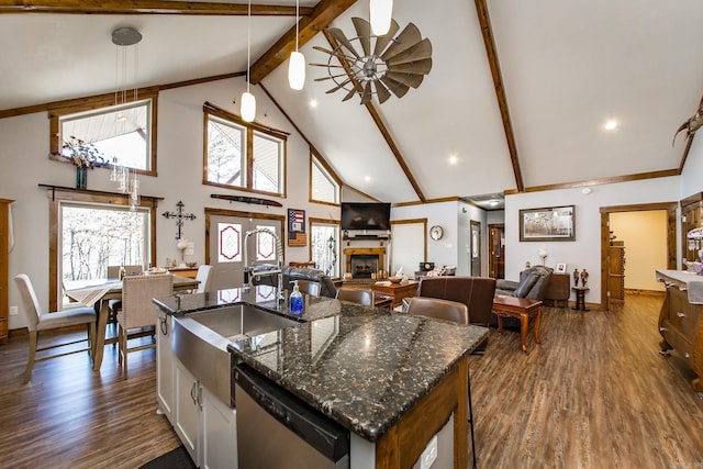 kitchen with high vaulted ceiling, stainless steel dishwasher, dark hardwood / wood-style flooring, beamed ceiling, and dark stone counters