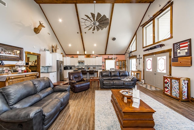 living room with beam ceiling, high vaulted ceiling, light hardwood / wood-style floors, and ceiling fan