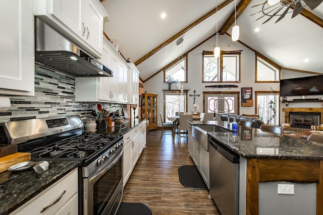 kitchen featuring decorative light fixtures, appliances with stainless steel finishes, white cabinets, beam ceiling, and exhaust hood