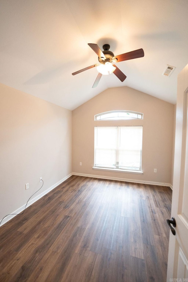 spare room featuring dark wood-type flooring, ceiling fan, and vaulted ceiling