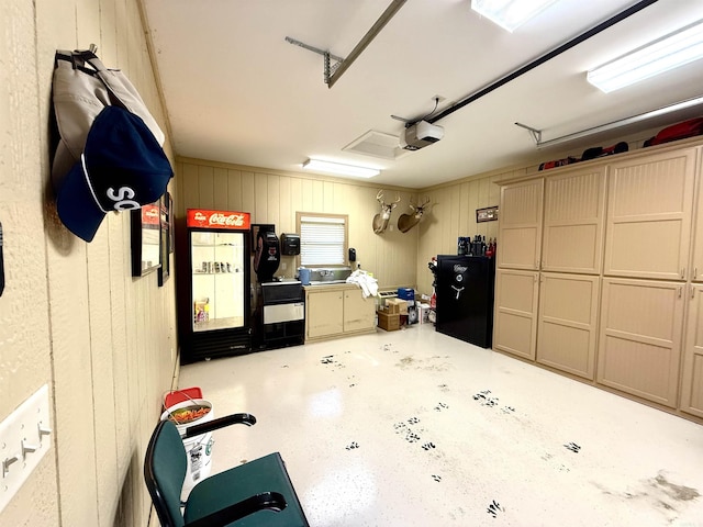 garage featuring a garage door opener and wooden walls