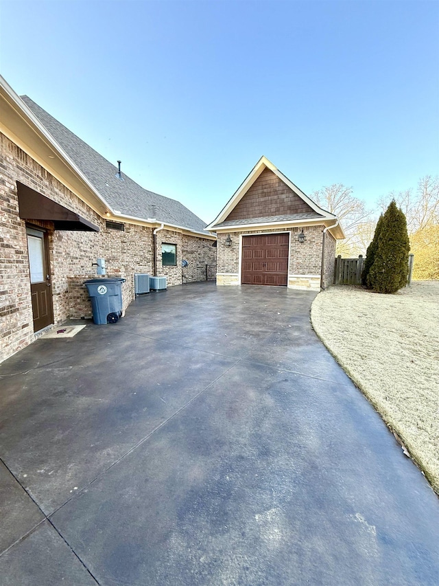 view of property exterior with a garage and central AC unit