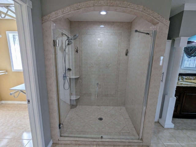 bathroom with tile patterned flooring, sink, and an enclosed shower