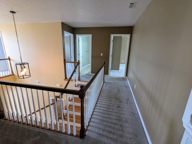 hallway featuring carpet and an inviting chandelier