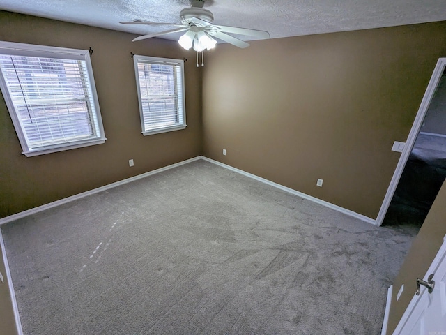 empty room featuring ceiling fan, carpet flooring, and a textured ceiling