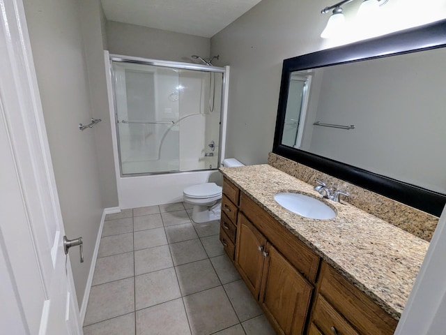 full bathroom featuring tile patterned floors, toilet, combined bath / shower with glass door, and vanity