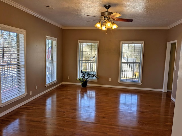 empty room with crown molding, plenty of natural light, and dark wood-type flooring