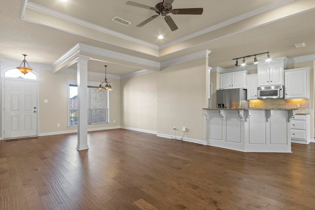 interior space featuring crown molding, rail lighting, decorative columns, dark hardwood / wood-style flooring, and ceiling fan with notable chandelier