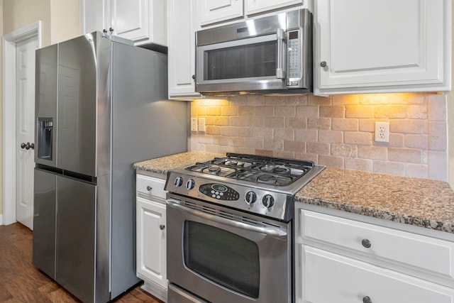 kitchen featuring light stone counters, backsplash, white cabinets, and appliances with stainless steel finishes