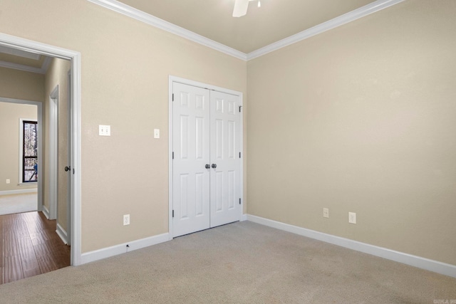 unfurnished bedroom featuring ceiling fan, ornamental molding, carpet floors, and a closet