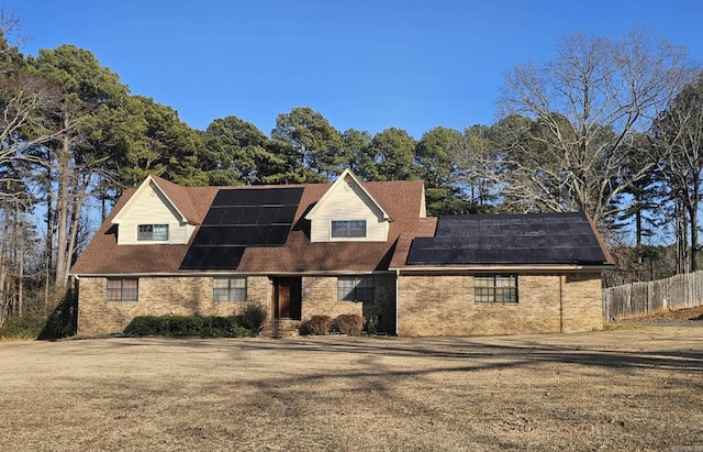 view of front facade with a front lawn and solar panels