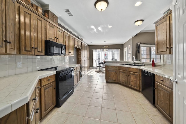 kitchen featuring light tile patterned flooring, backsplash, sink, and black appliances