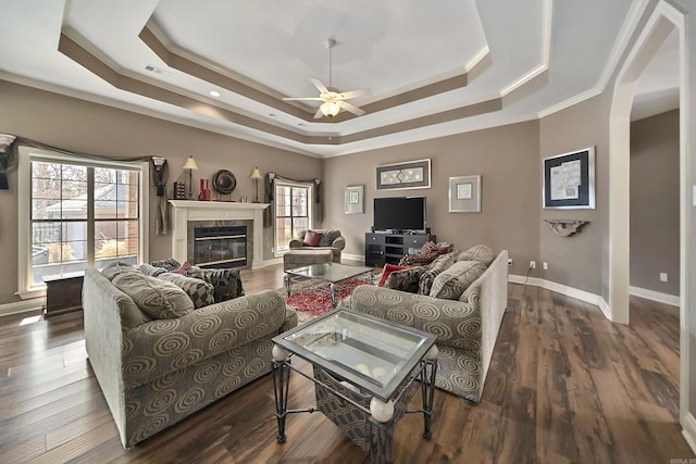 living room featuring crown molding, ceiling fan, dark hardwood / wood-style floors, and a raised ceiling