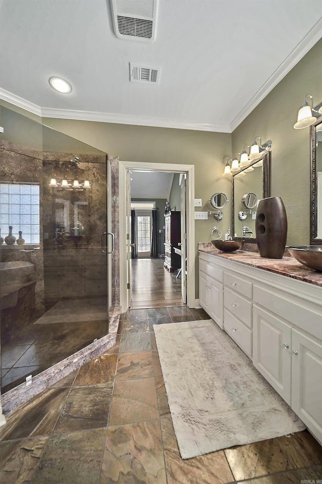 bathroom with vanity, crown molding, and walk in shower