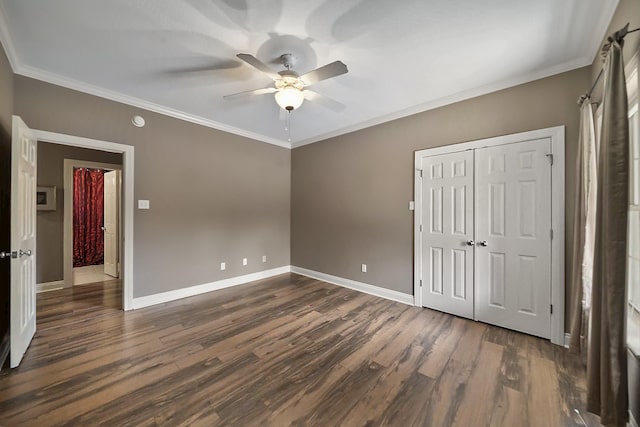 unfurnished bedroom featuring crown molding, ceiling fan, dark hardwood / wood-style flooring, and a closet