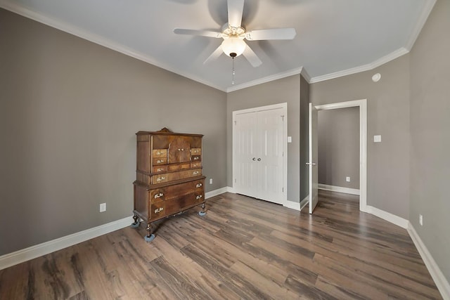 bedroom featuring crown molding, dark wood-type flooring, ceiling fan, and a closet