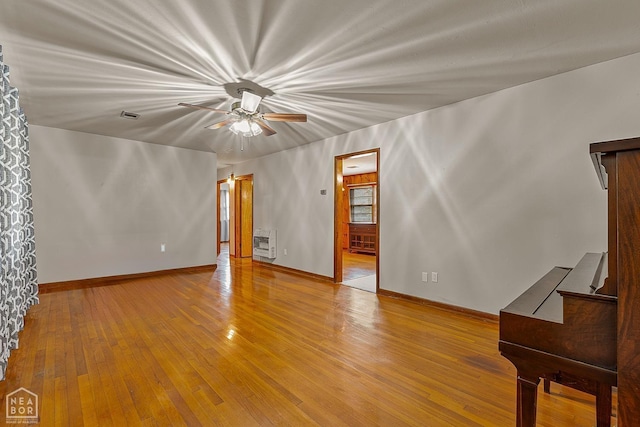 unfurnished living room featuring hardwood / wood-style flooring and heating unit