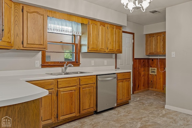 kitchen featuring stainless steel dishwasher, a chandelier, sink, and wood walls