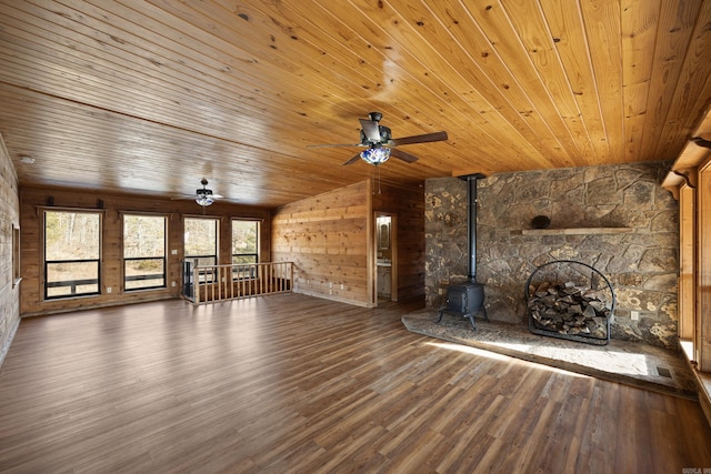 unfurnished living room featuring vaulted ceiling, a wood stove, hardwood / wood-style floors, and wooden ceiling