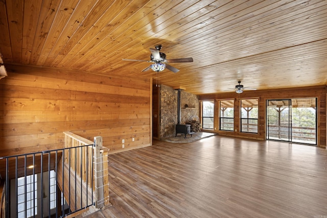 unfurnished living room with hardwood / wood-style flooring, a wood stove, and wood ceiling