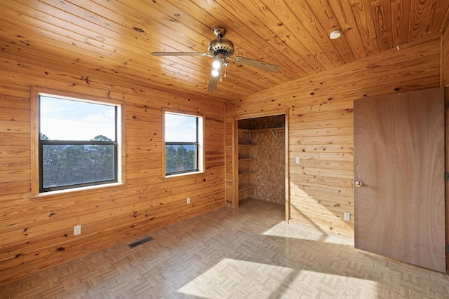 spare room with wood ceiling, lofted ceiling, light parquet floors, and wood walls