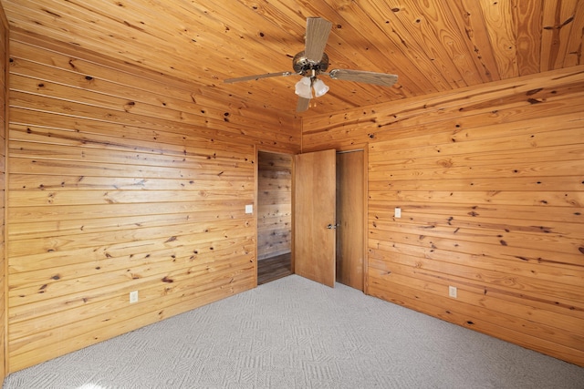 spare room with wood ceiling, ceiling fan, carpet floors, and wood walls